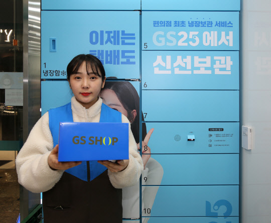 편의점 GS25 BOX25 앞에서 모델이 TV홈쇼핑 GS샵 박스를 들고 서 있다. <GS리테일 제공>